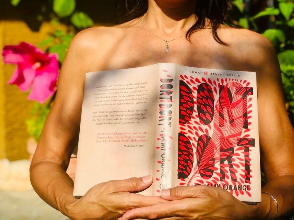 Annette König hält sich den Roman «Dort Dort» von Tommy Orange vor die Brust. 