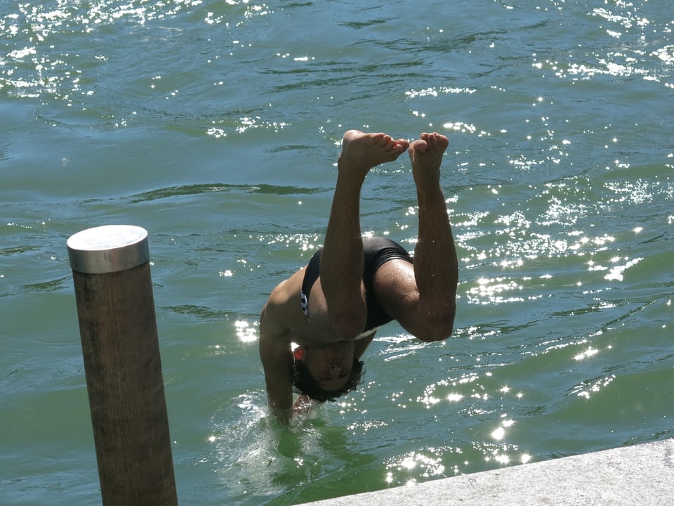 Ein Mann springt ins Wasser.