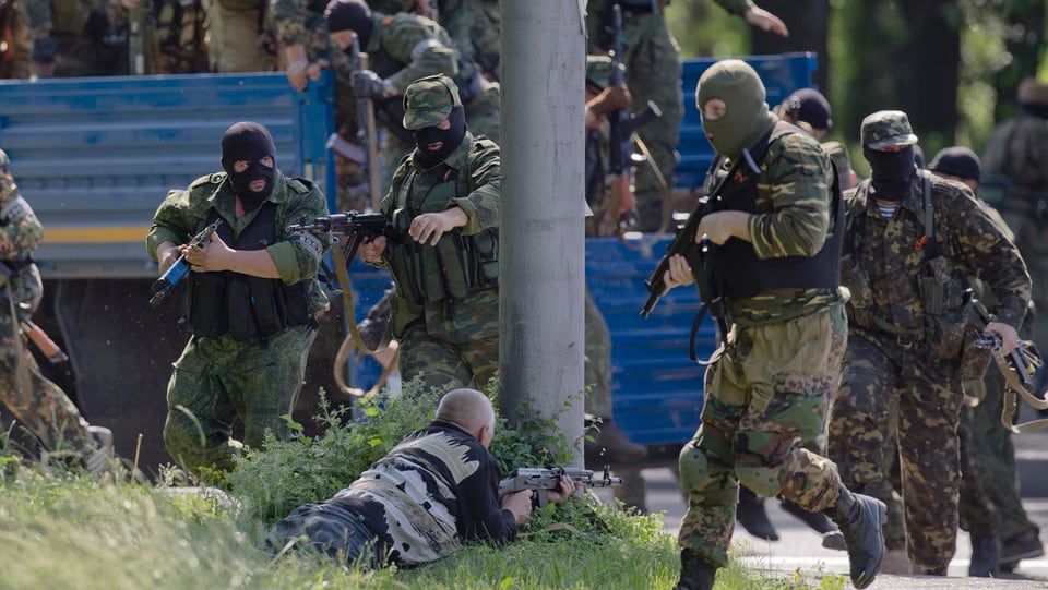 Prorussische maskierte Kämpfer halten ihre Waffen im Anschlag