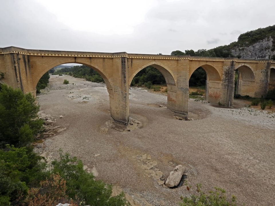 Blick auf eine Steinbrücke über dem ausgetrockneten Gardon-Fluss in Frankreich.