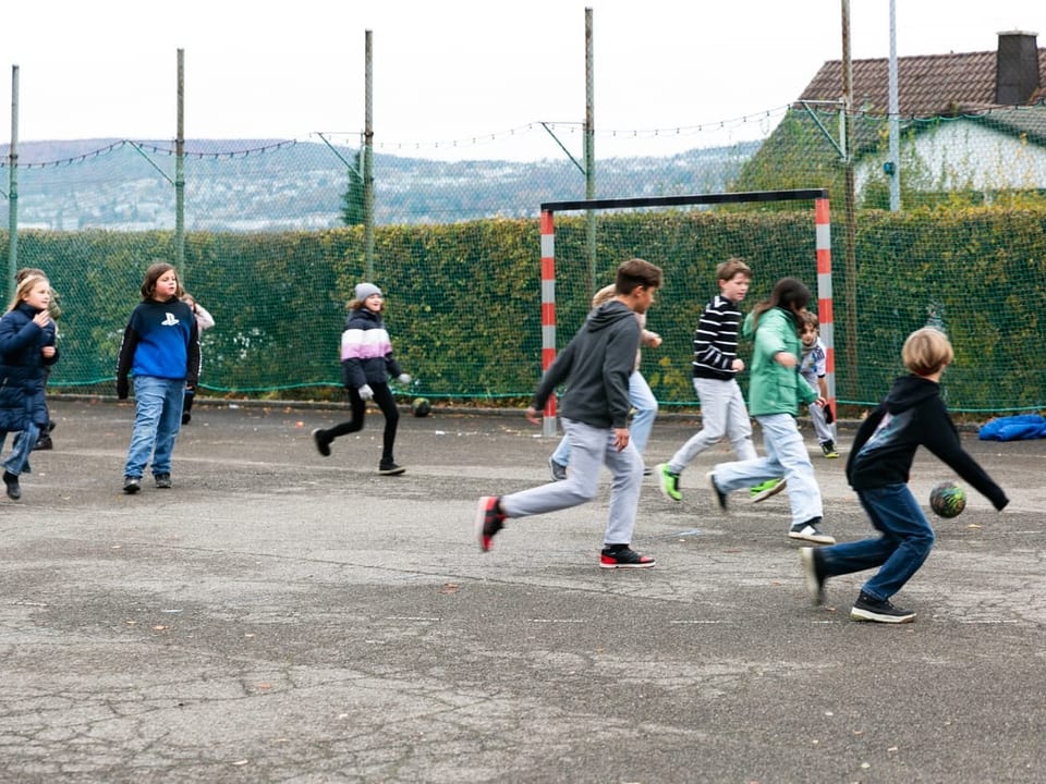 Eine Gruppe Kinder spielt zusammen mit Denys Fussball.
