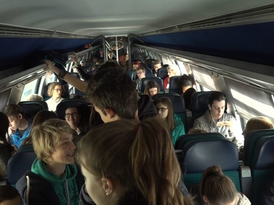 Jugendliche in einem überfüllten Zug. 