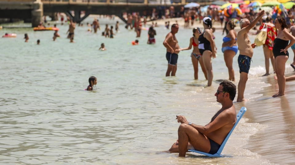 Menschen kühlen sich am Strand von Mondello in Palermo ab.