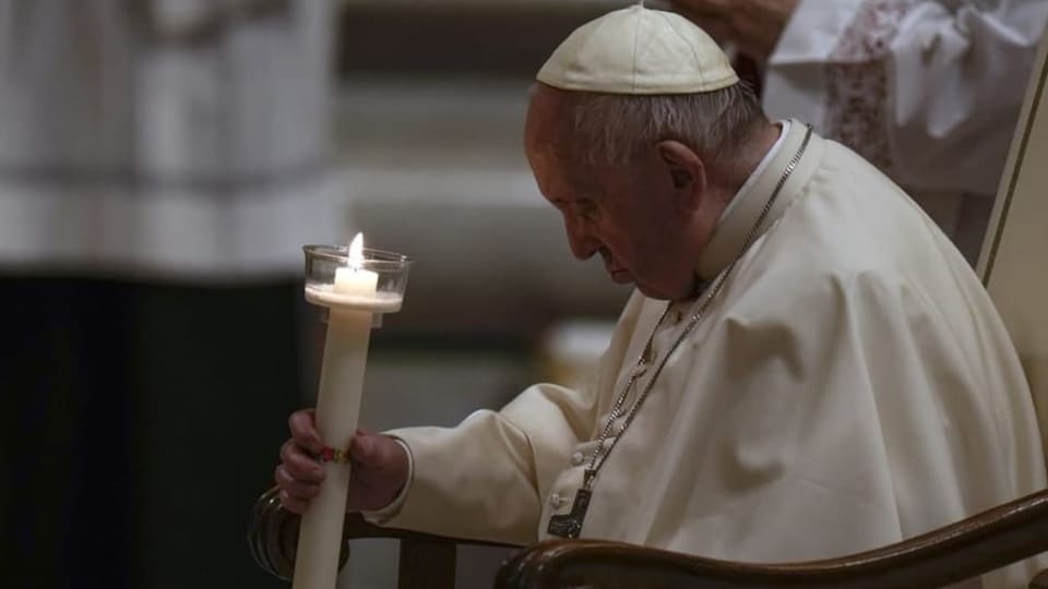 Papst Franziskus hält eine Kerze in der Hand