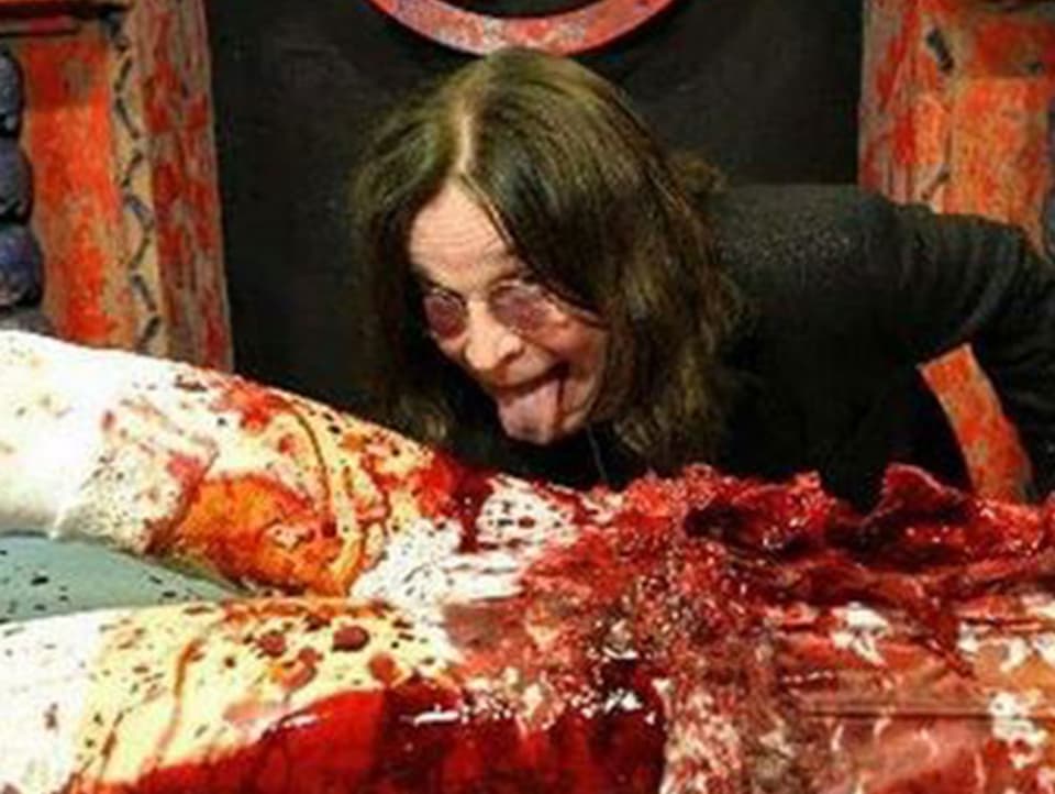 Ozzy Osbourne schleckt an einer blutigen Puppe.