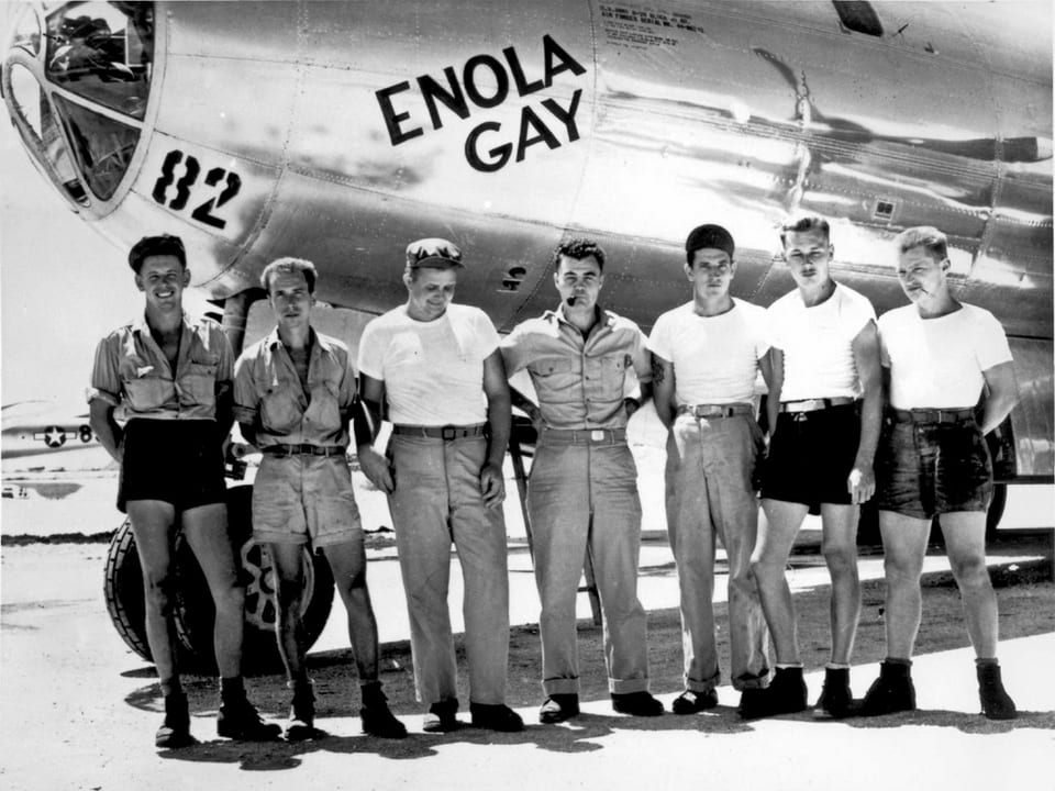Die Mannschaft der Enola Gay stehend vor der Maschine.