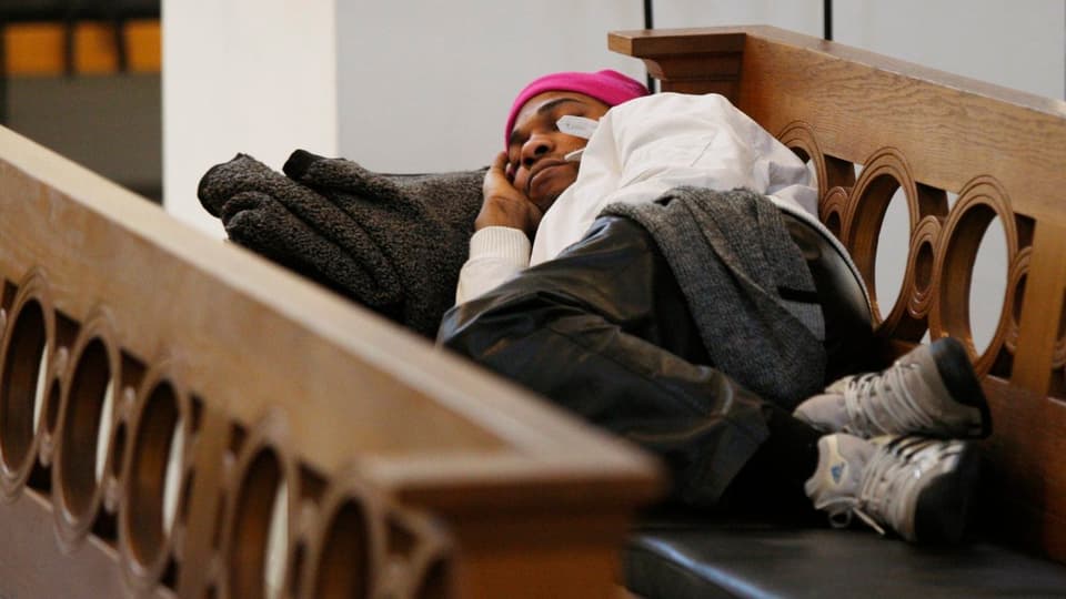 Ein Flüchtling ohne Papiere schläft auf einer Kirchenbank 