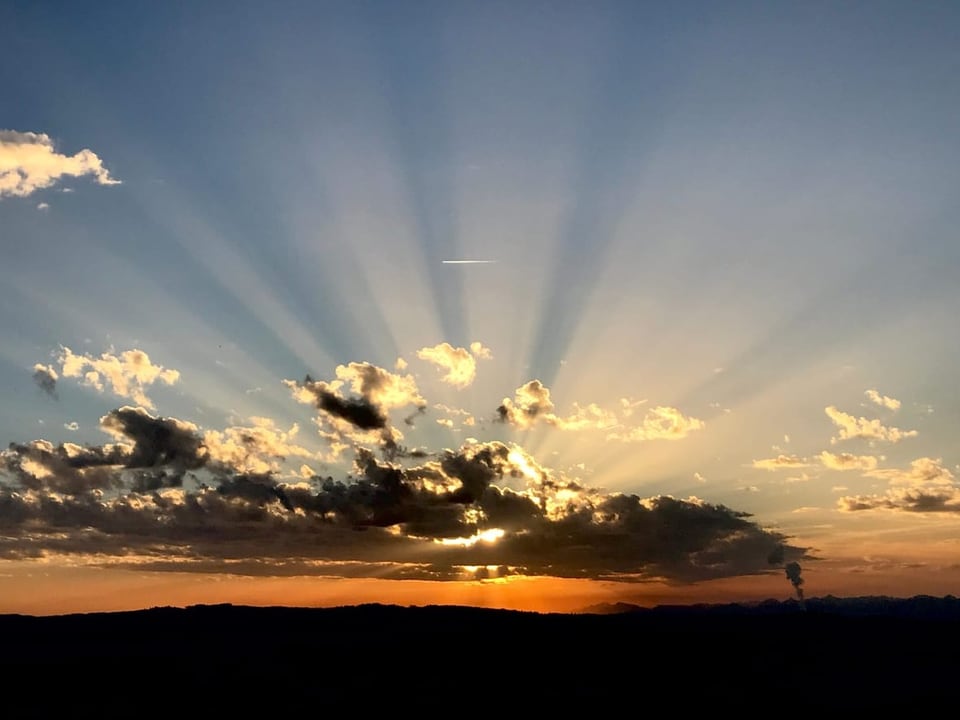 Bellikon/AG Sonnenuntergang hinter Wolken mit sichtbaren Sonnenstrahlen