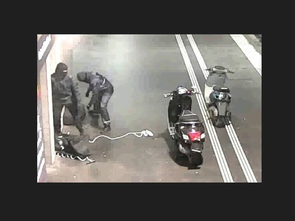 Die Täter sind mit zwei Motorrollern vor dem Automaten.