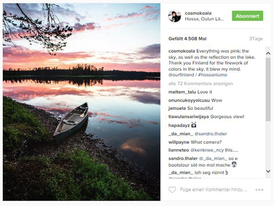 Ein Kanu steht am Ufer eines spiegelglatten Sees in Finnland.