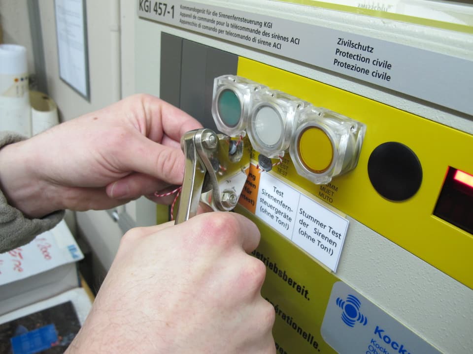 Übungsleiter Gregor Mrhar plombiert den Knopf für die Alarmauslösung, nachdem er gedrückt worden war.