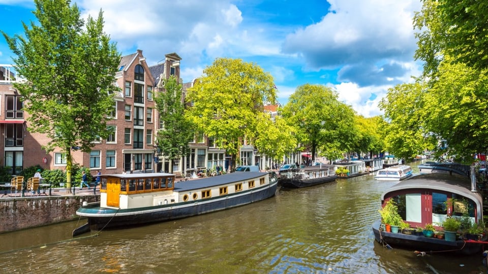 Ein Kanal zwischen zwei Häuserreihen in Amsterdam mit Hausbooten