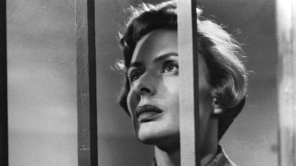 Ingrid Bergman hinter Gitterstäben, nach oben schauend.