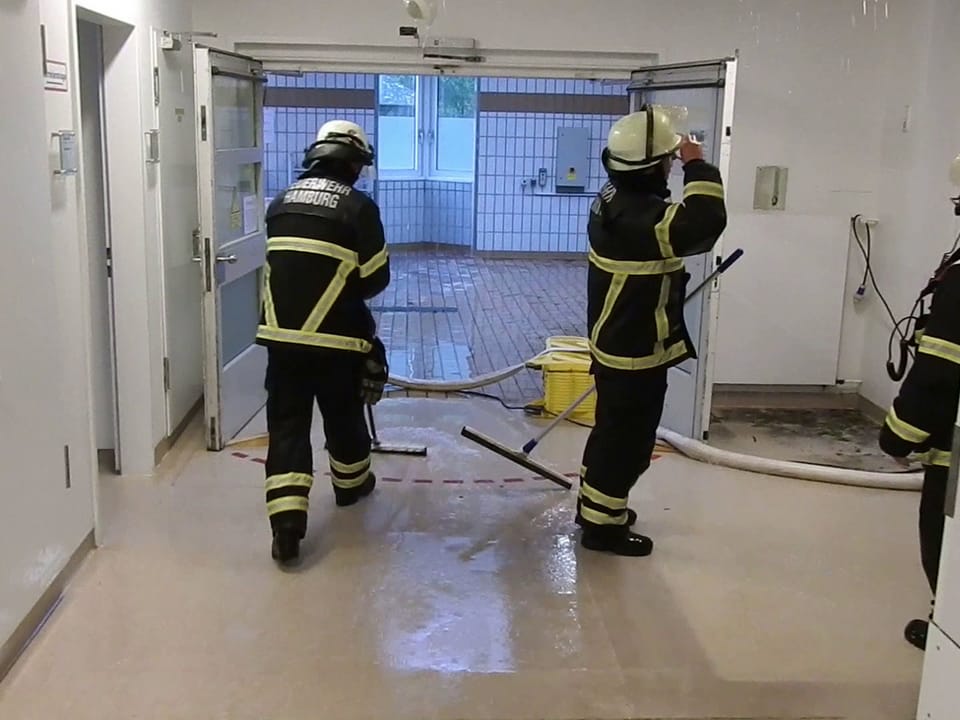 Feuerwehrleute in einem überfluteten Raum