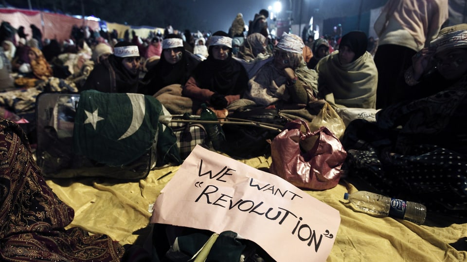 Demonstranten mit dem Plakat: "We want Revolution".