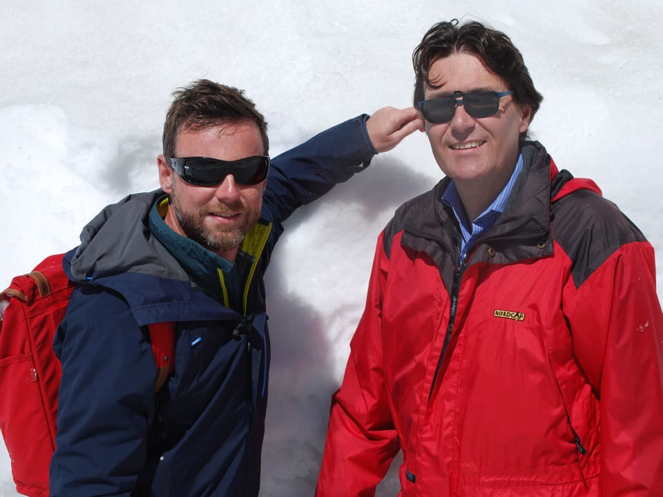 Nik Hartmann und ein anderer Mann stehen vor einer Schnee- resp. Eiswand. 