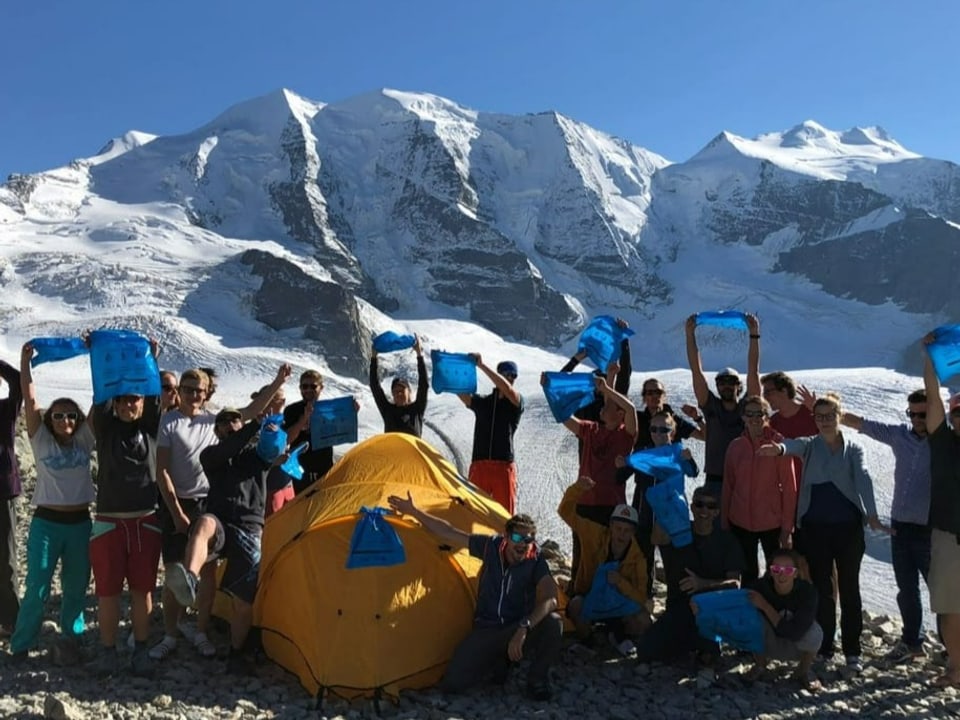 Clean-Up Team hält jubelnd leere Abfallsäcke in die Höhe.