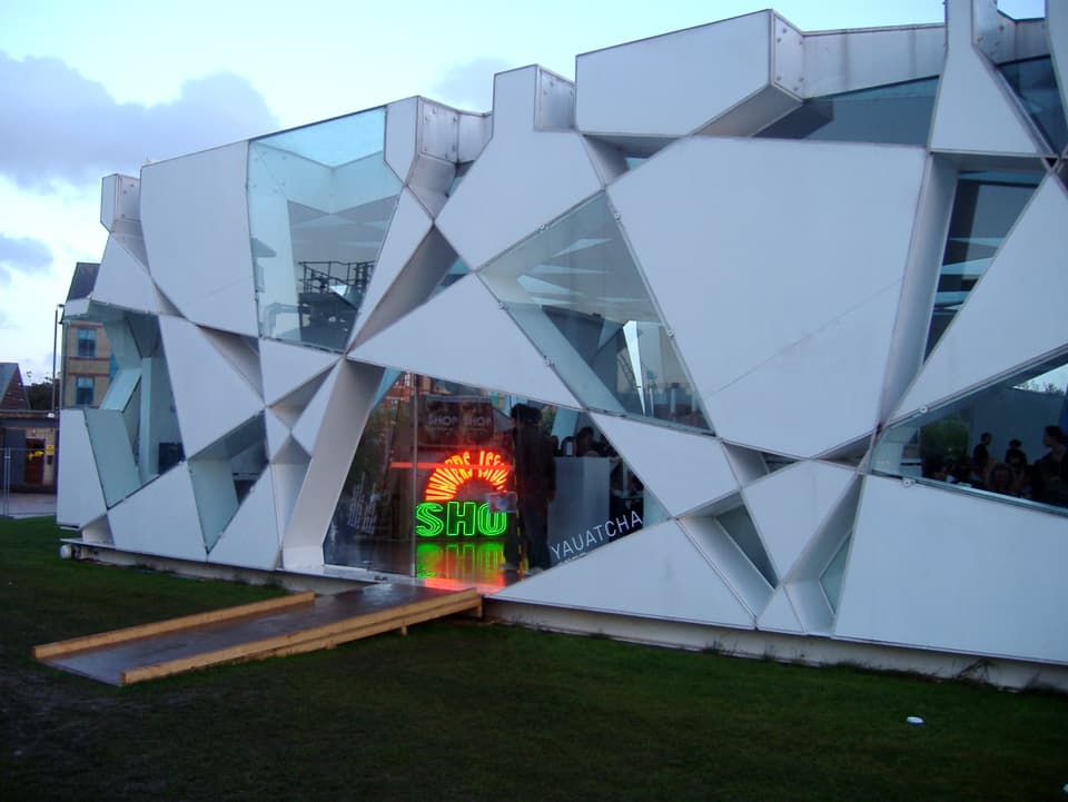 Serpentine Pavillon mit einer weissen Fassade, die aussieht wie ein zersplitterter Spiegel.