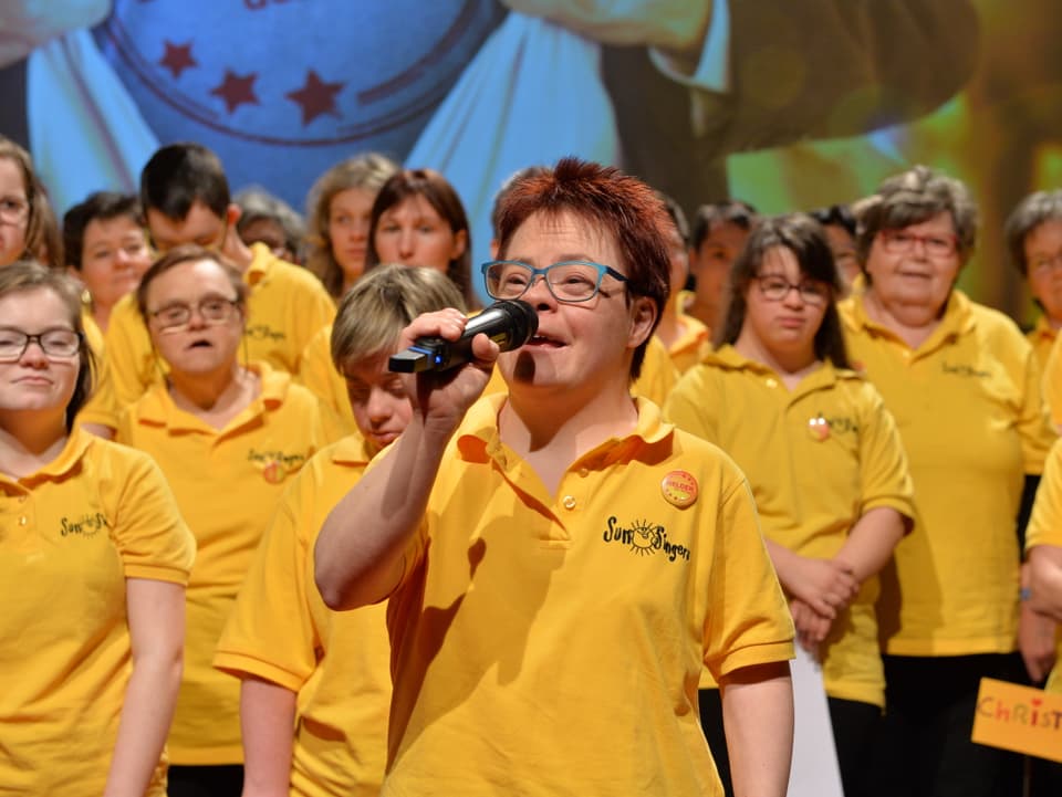 Chor in gelben T-Shirts am Singen.