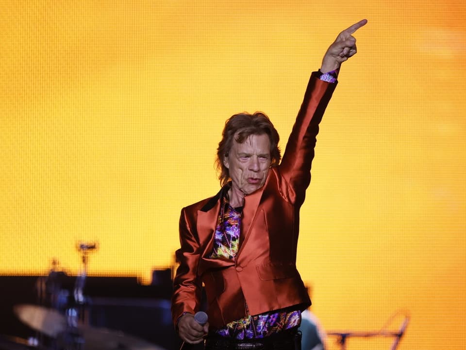 Mick Jagger, der Sänger der Rolling Stones, auf der Bühne mit einer roten Jacke.