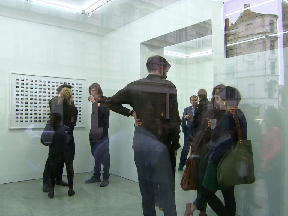 Vernissage einer Ausstellung von Julian Charrrière: Mehrere Personen unterhalten sich stehend.