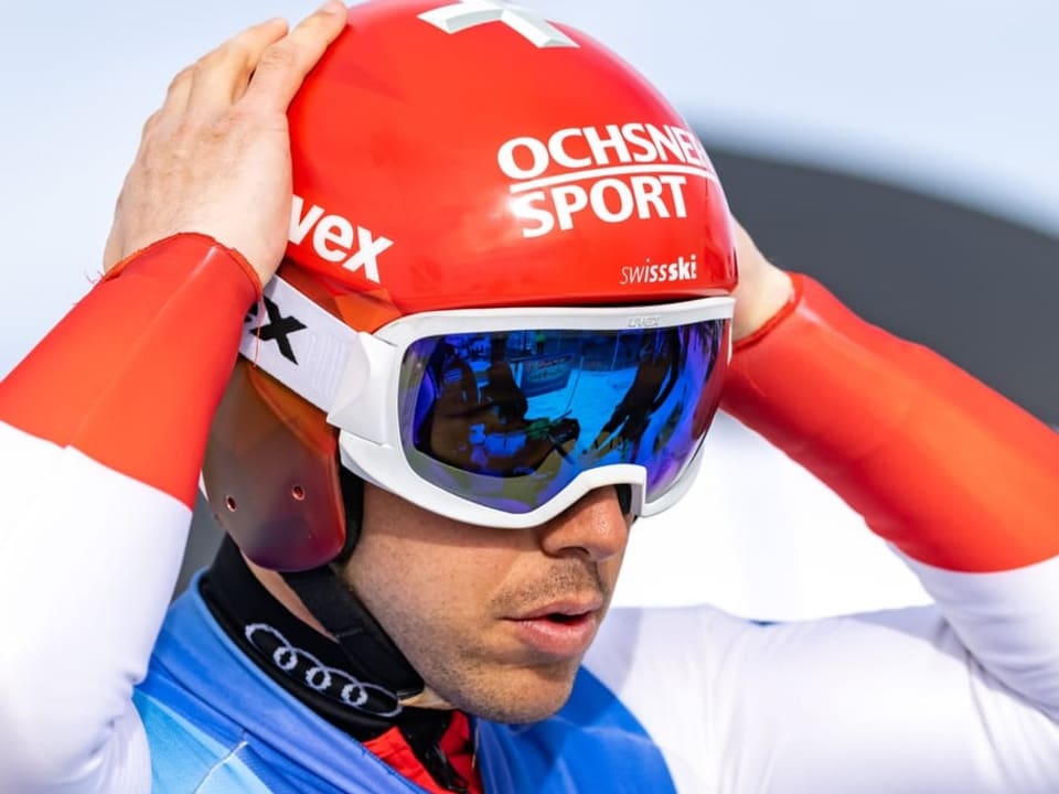 Doch noch startklar für den Winter 2021/22 Carlo Janka greift mit beiden Händen an den aufgesetzten Helm.