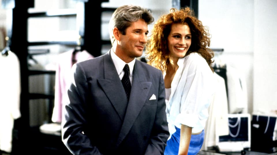 Richard Gere im Anzug neben Julia Roberts in einem Geschäft im Film «Pretty Woman». 