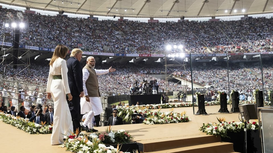 Donald und Melania Trump sowie Narendra Modi betreten die Bühne in einem voll besetzten Stadium.