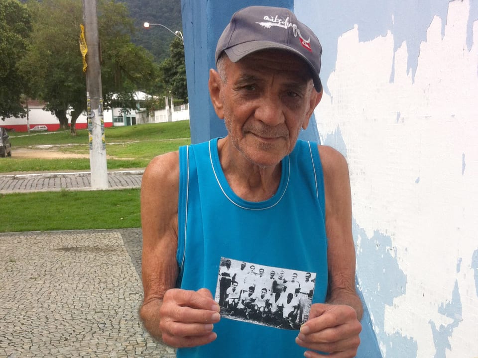 Ein alter Mann hält ein Foto in der Hand.