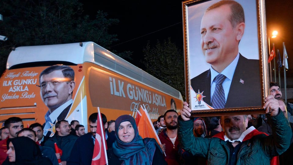 Anhänger der AKP halten ein Bild von Erdogan in die Höhe