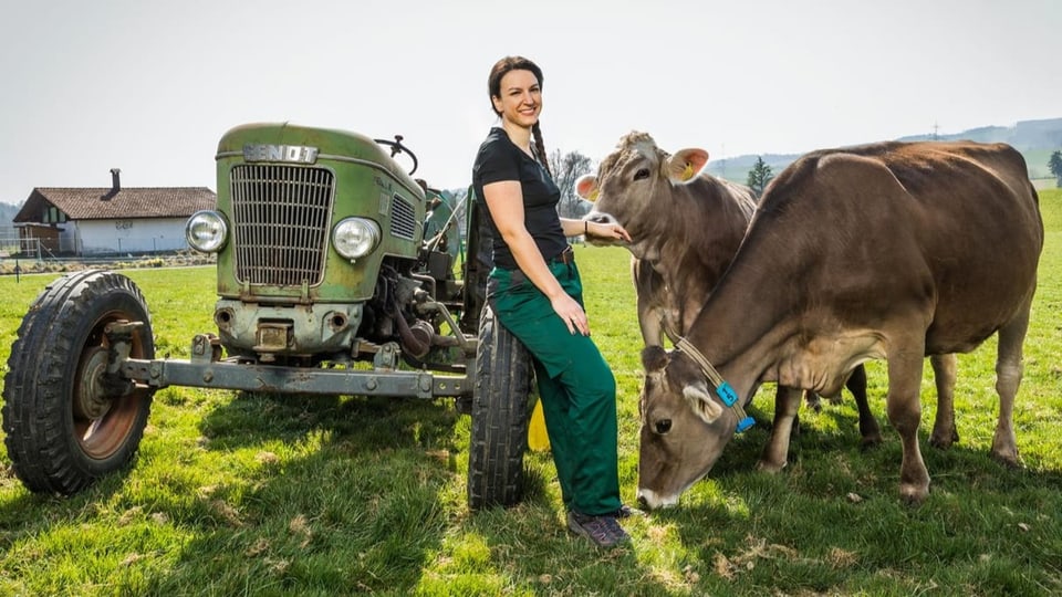 Landfrau Daniela Huwiler auf dem Feld mit zwei ihrer Kühe.
