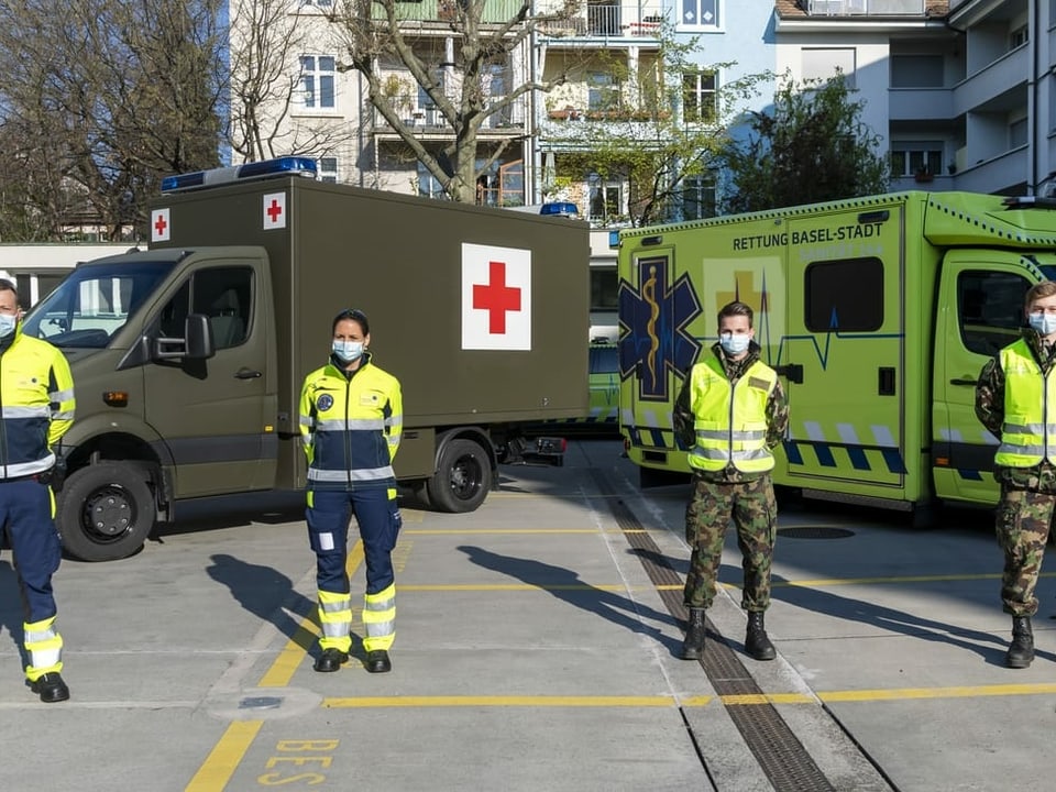 Soldaten und Sanitäter vor Fahrzeugen 