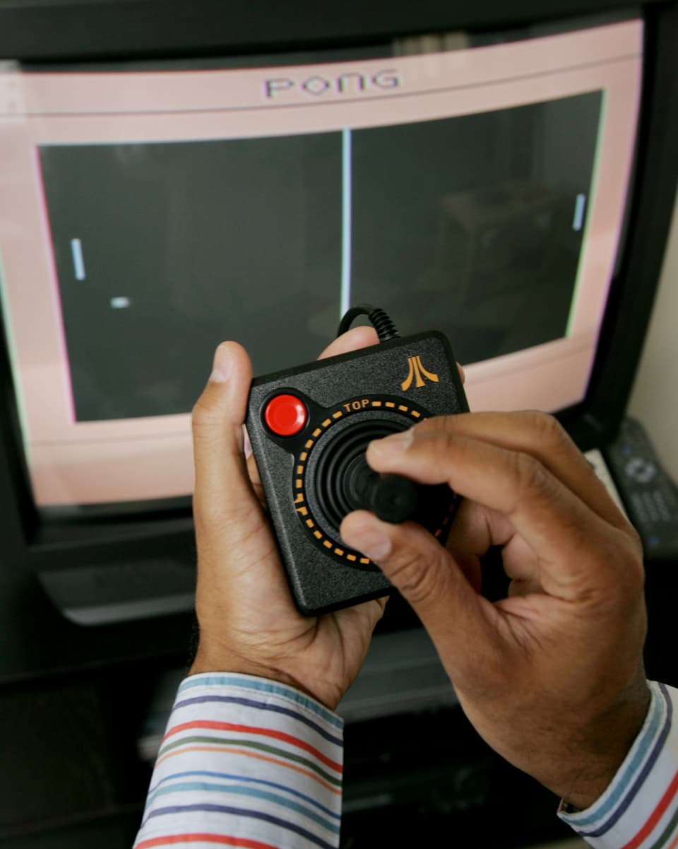 Ein Mann sitzt vor einem Computer und spielt ein Atari-Game.