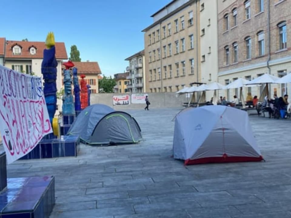 Zelte und Protestbanner auf einem öffentlichen Platz in der Stadt