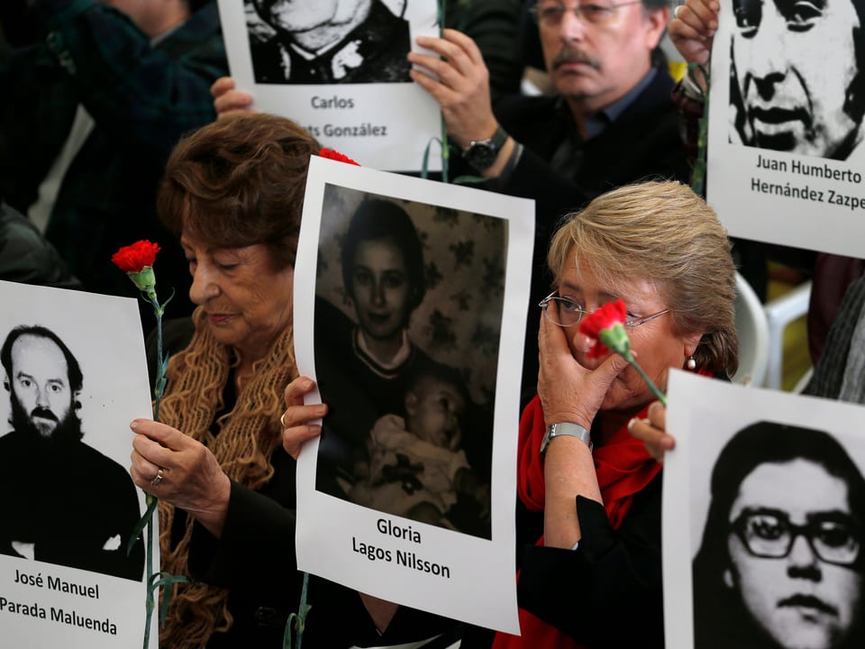 Auch die frühere chilenische Präsidentin Michelle Bachelet weint mit einem Bild in der Hand.