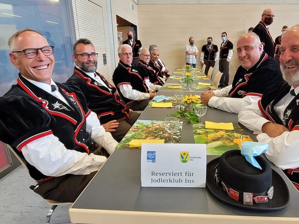 Lachende Männer eines Jodlerchors am Tisch.