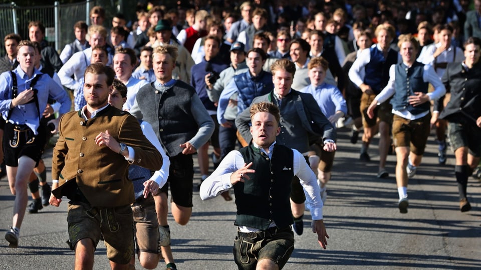 Junge Männer in Lederhosen rennen