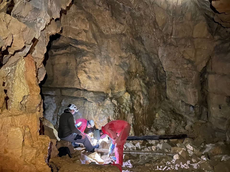 Die Speläologen untersuchen aktiv den Boden der Höhle.