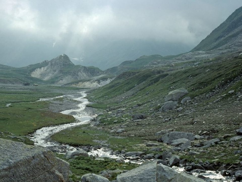 Fluss in der Mitte, im Hintergrund Berge