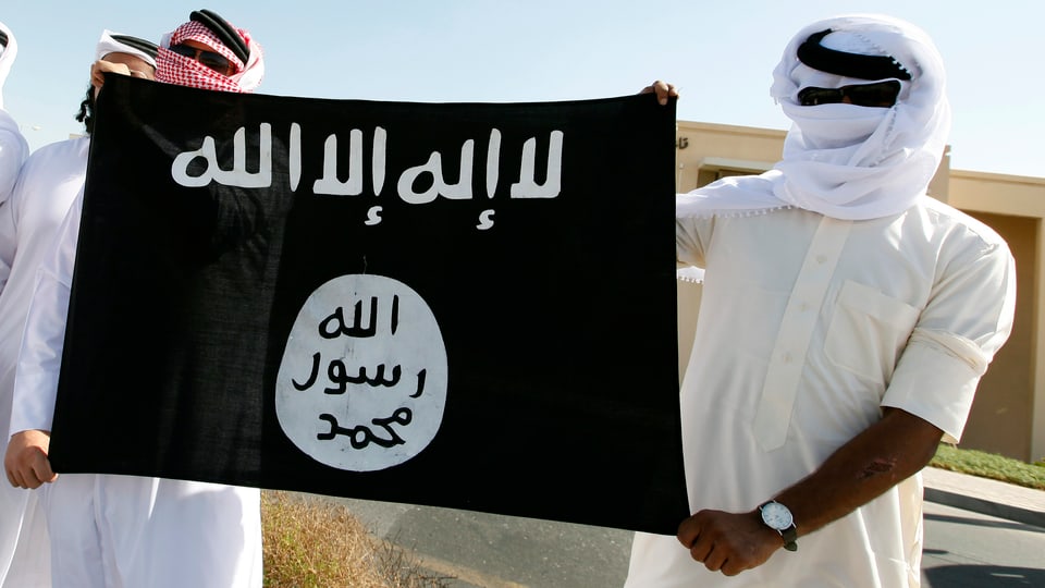 Männer halten die Flagge der IS