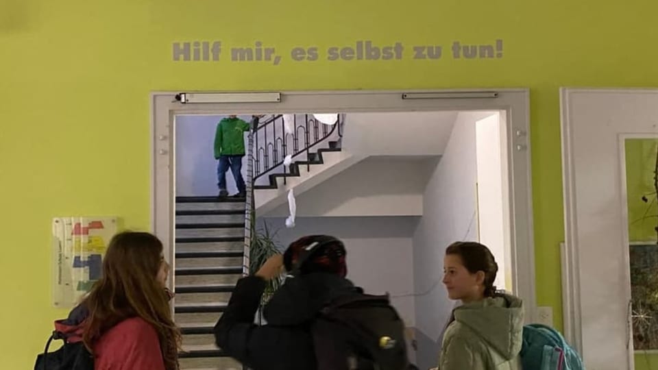 Das Montessori-Motto Kinderreporterin Gioanna, Reporterin Julia und Mia stehen vor der Motto der Montessori Schule.