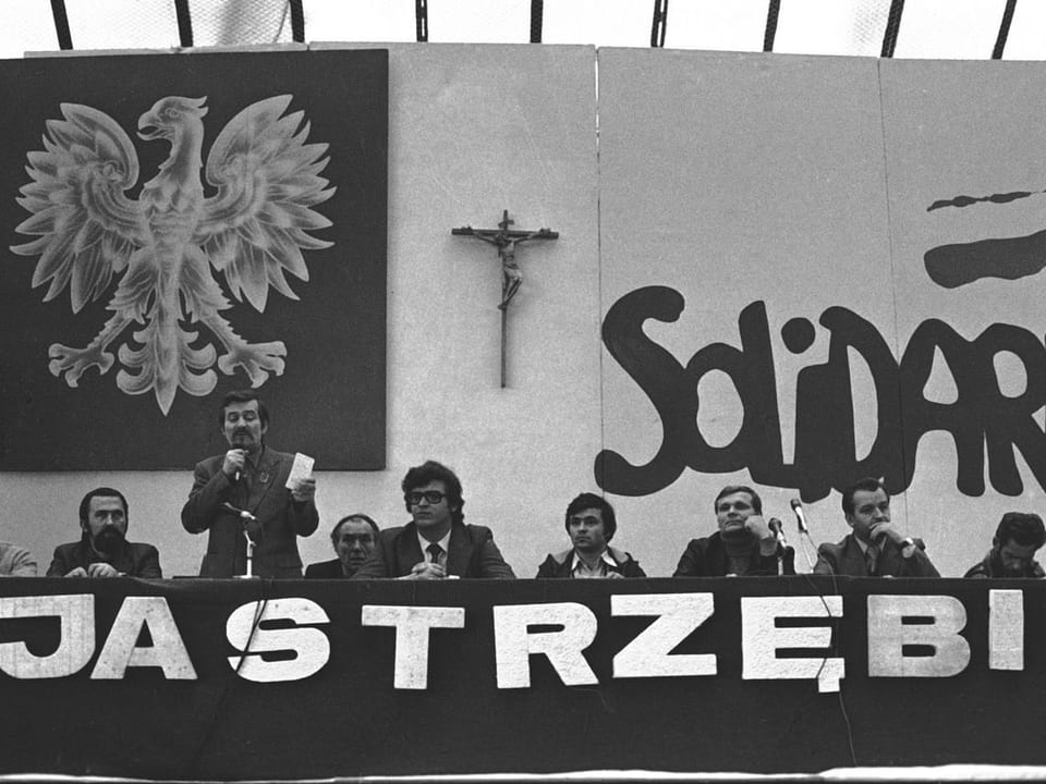 Gewerkschaftsführer vor einer Solidarność-Fahne