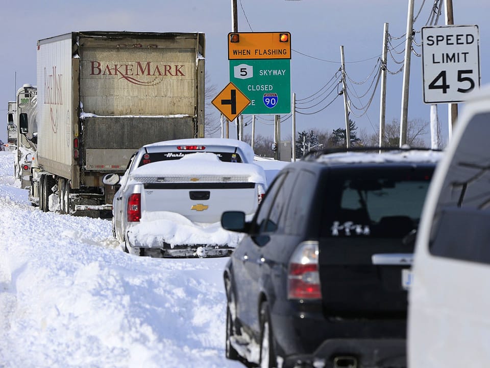 Autokolonne auf schneebedeckter Autobahn fahrend