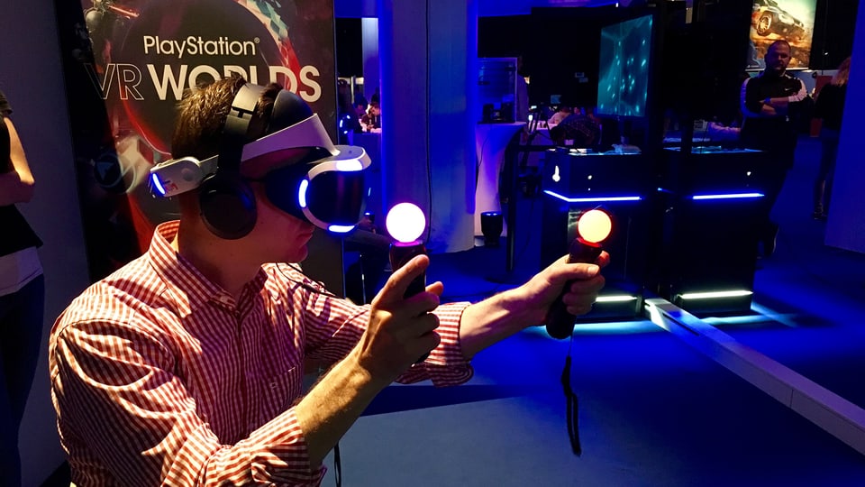 Ein Mann mit Virtual-Reality-Brille und Controllern mit leuchtenden Punkten in der Hand
