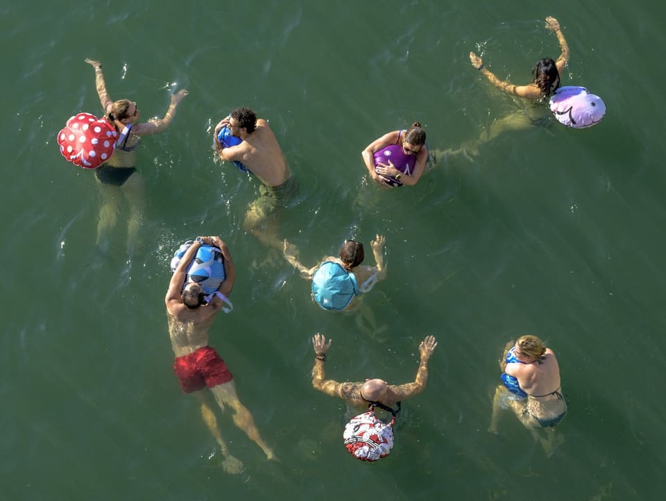 Vogelperspektive: Menschen im Wasser mit Schwimmsäcken