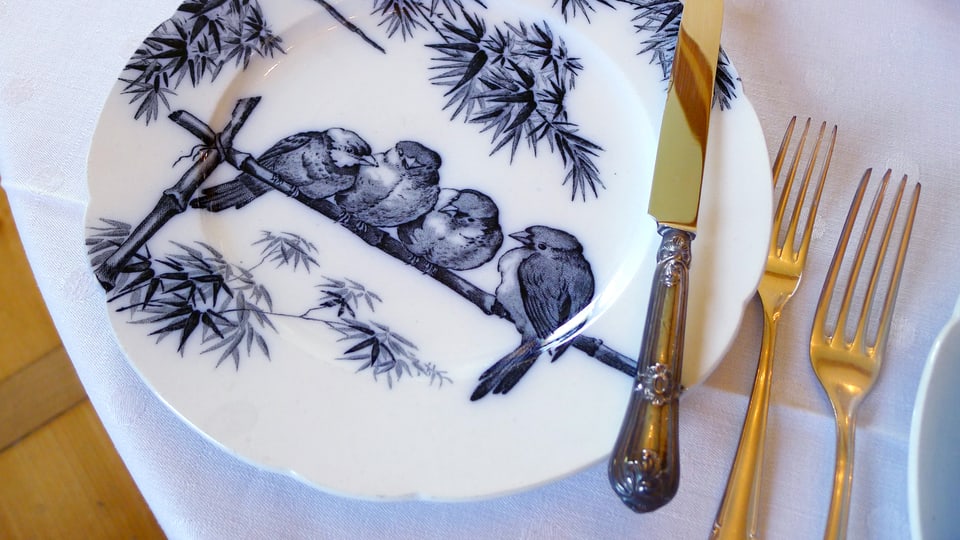 Ein Porzellanteller mit Vögeln.