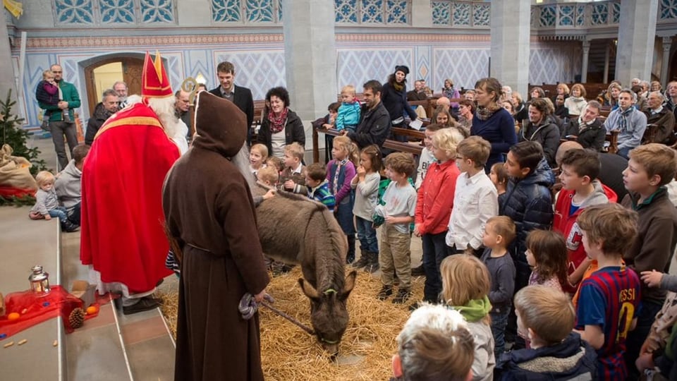 Samichlaus, Schmutzli und Esel besuchen Kinder in der Kirche. 