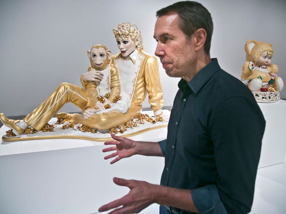 Der Künstler Jeff Koons präsentiert seine Werke. Er steht vor der Michael Jackson Skulptur