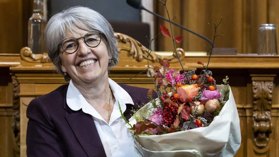 Elisabeth Baume-Schneider strahlt mit einem Blumenstrauss in der Hand