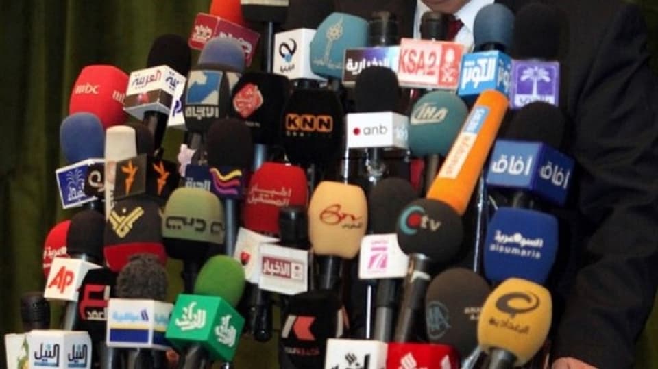 Viele bunte Mikrophone vor Rednerpult